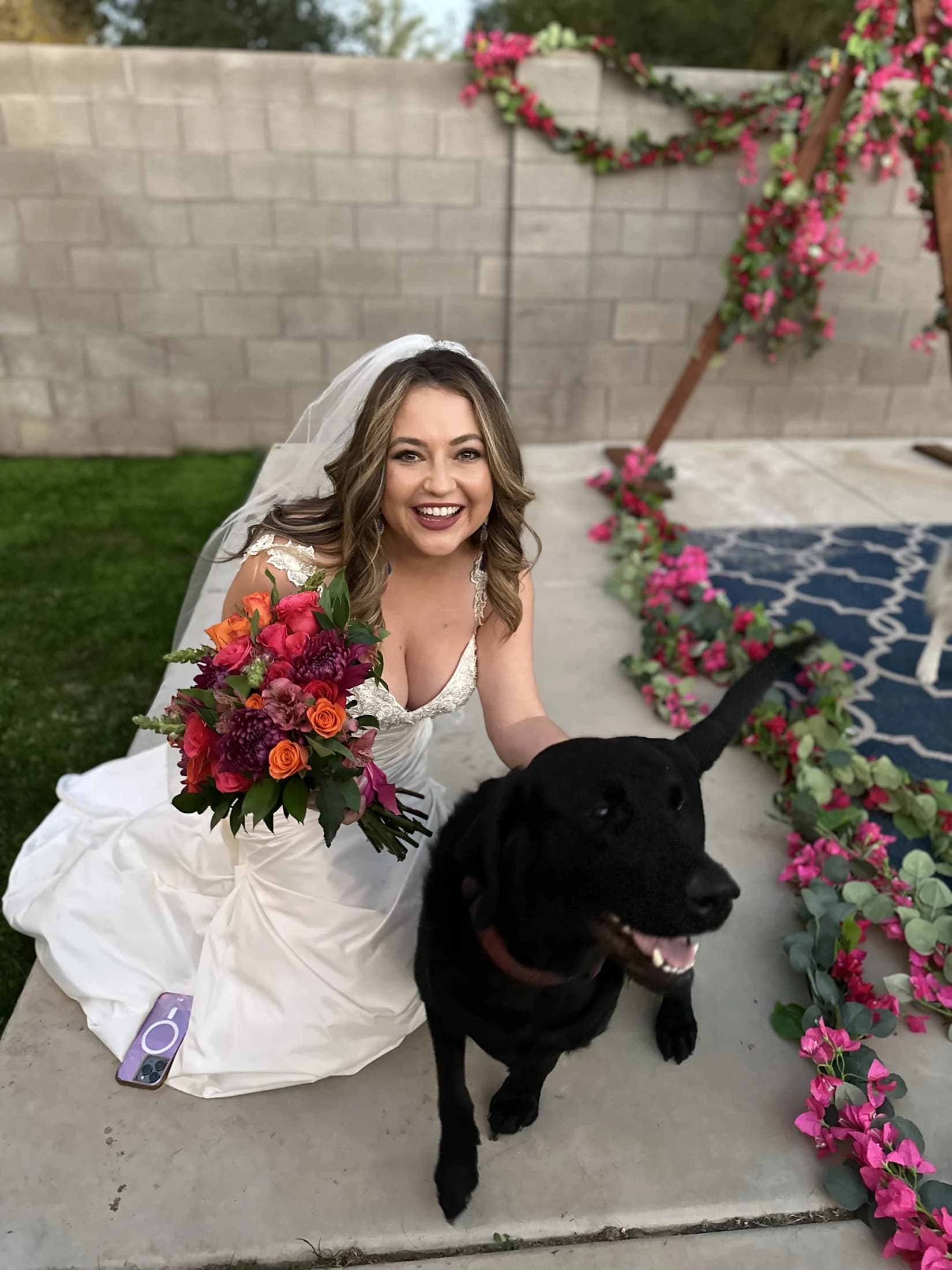 Elena in her wedding dress beside a black dog