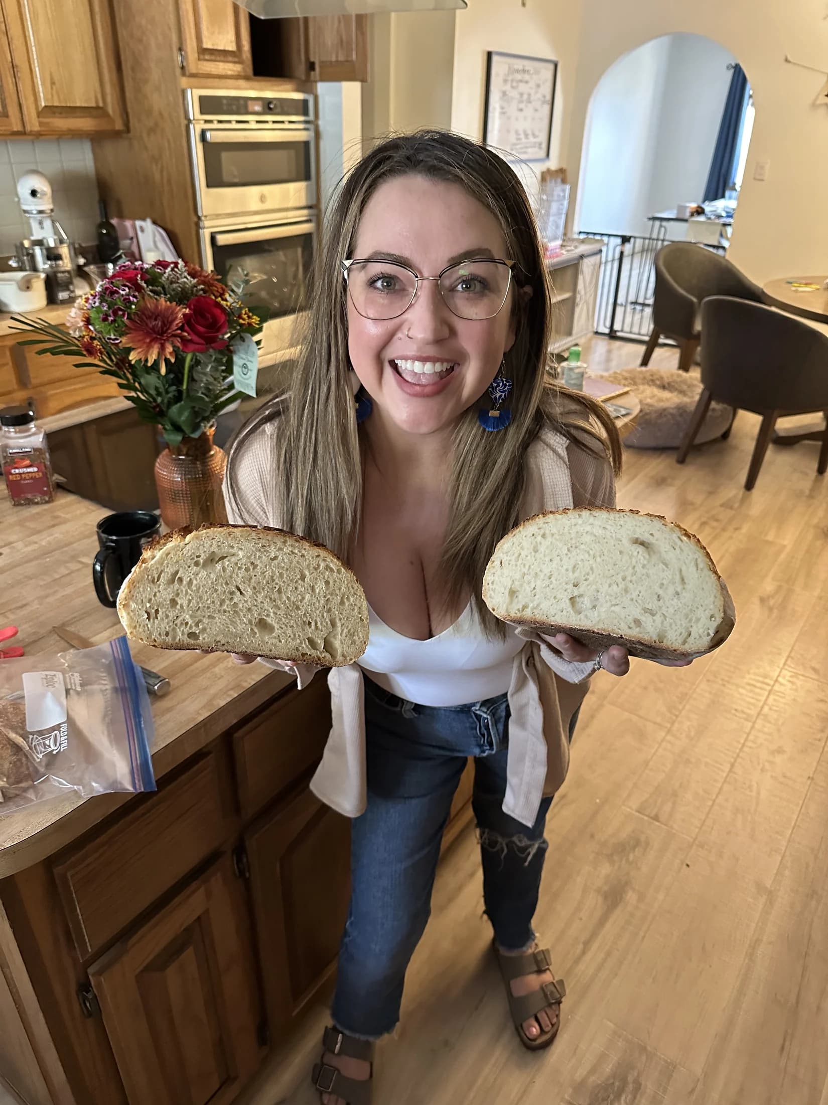 Elena smiling in the kitchen with two halves of a homemade loaf