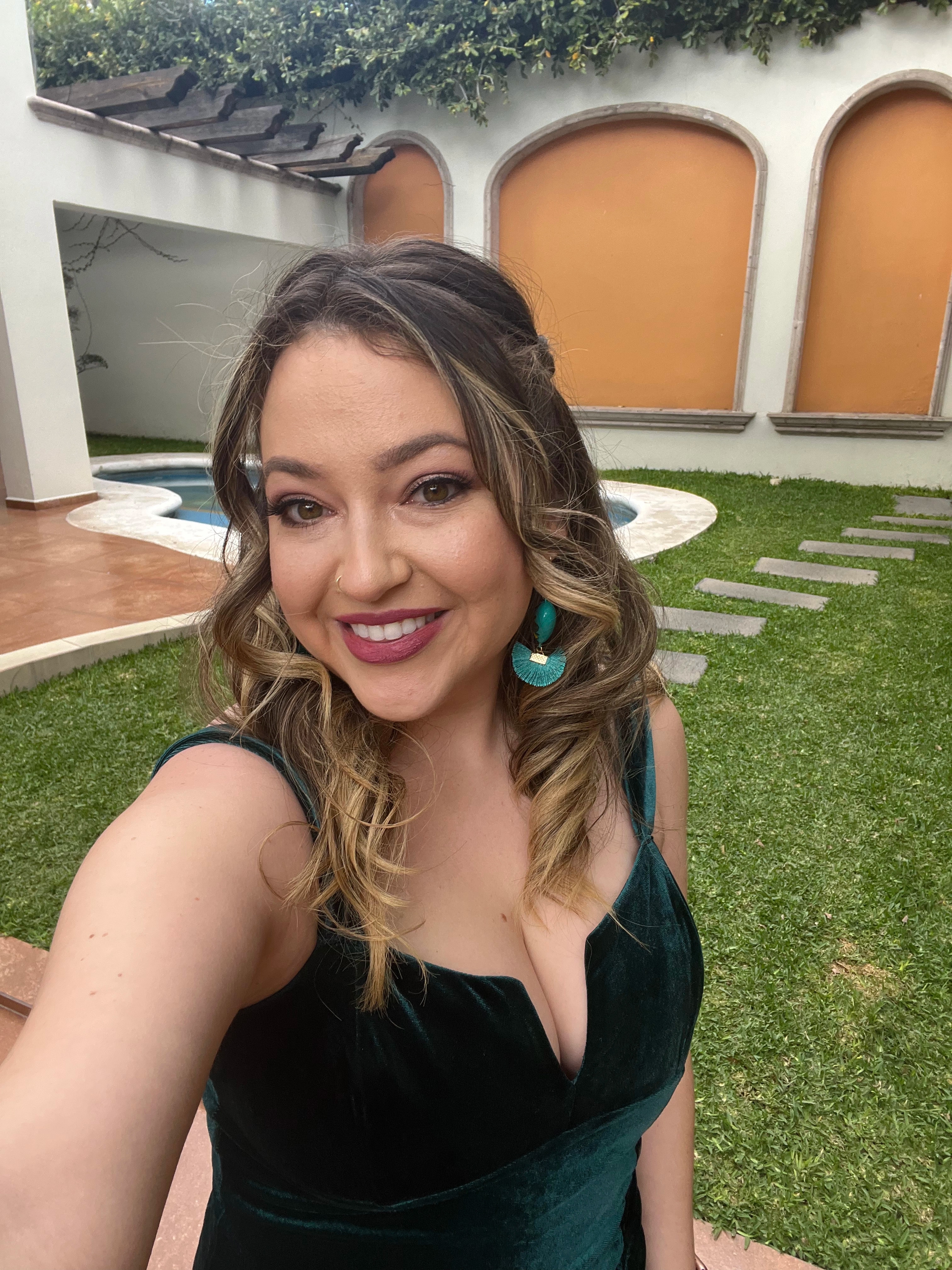 Elena dressed in green, smiling outside before a celebration